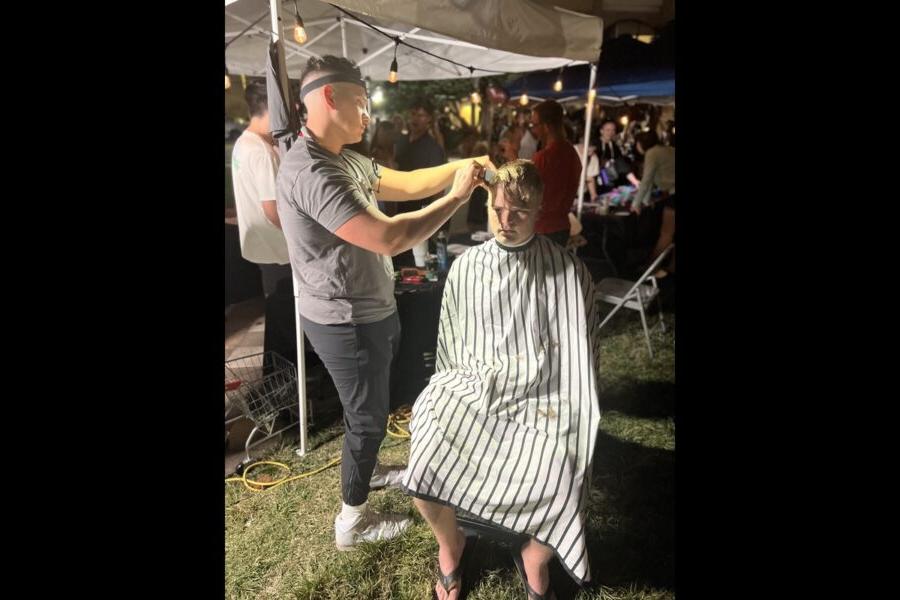 student getting a haircut at the 561 Night Market